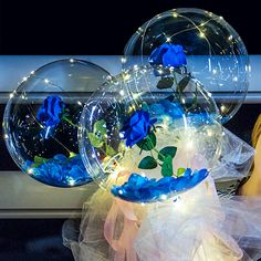 With string lights 3 Blue roses inside 3 transparent balloon with White and Blue Wrapping