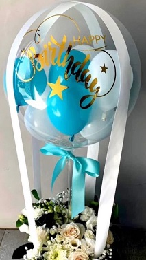 Small Blue and white balloons inside a trasparent balloon with 12 white flowers basket