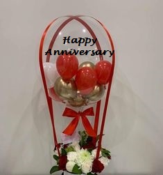 6 Small red and gold balloons with clear happy anniversary printed balloon bouquet decorated with 12 red and white roses flowers and red ribbons
