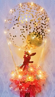 Golden confetti inside the transparent balloon tied to a box with 8 ferrero rocher chocolates in red net with illuminating fairy string lights