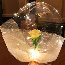 Transparent Balloon with 1 Yellow rose inside and wrapped in white and pale yellow wrapping and led fairy light string